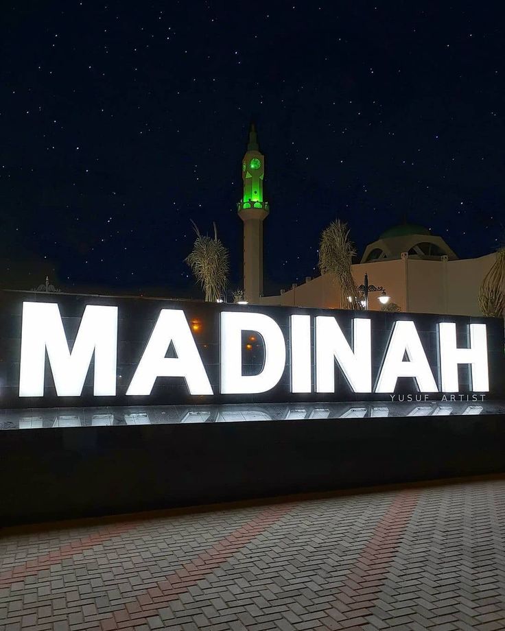 the sign for madinah is lit up at night