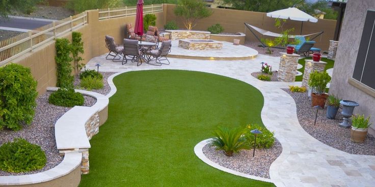 an outdoor patio with artificial grass and landscaping