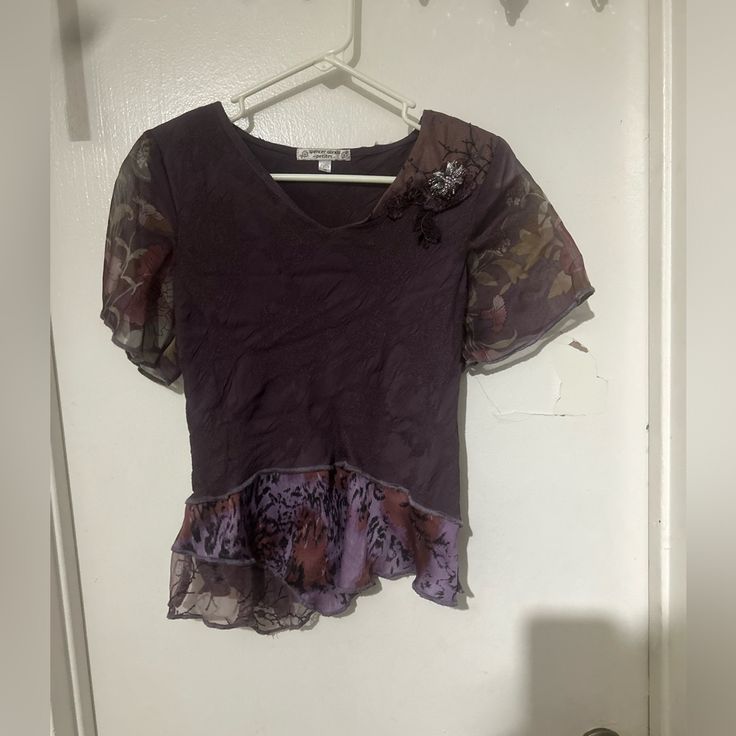 a shirt hanging on a hanger in front of a white door with an animal print design