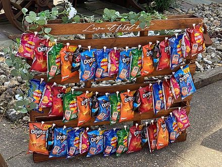 a wooden stand with candy bags hanging from it's sides on the side walk