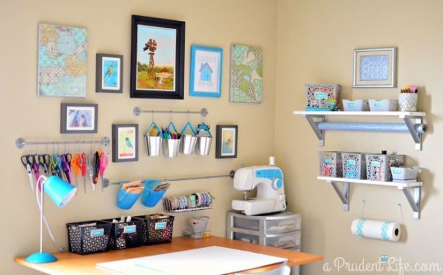 a sewing room with lots of crafting supplies on the wall and pictures above it