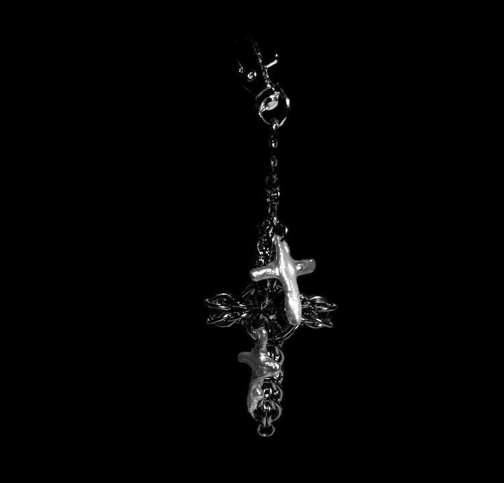 a black and white photo of a cross hanging from a chain