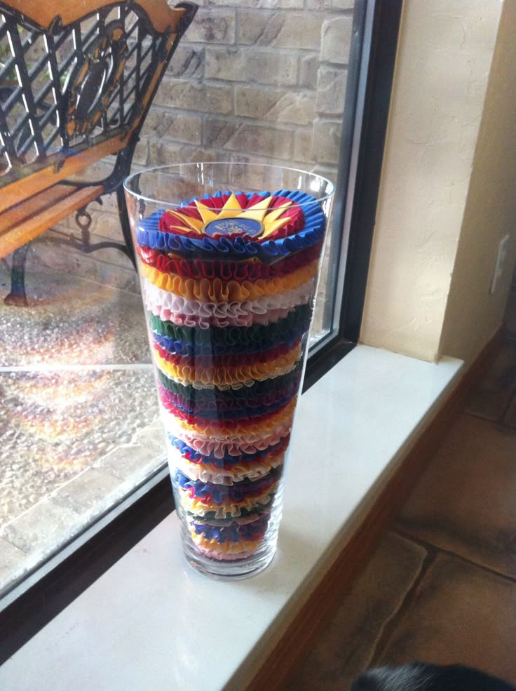 there is a vase that has been made out of crocheted yarn and sits on the window sill