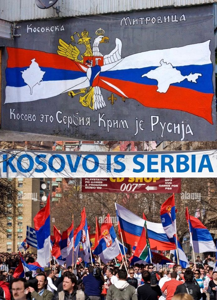 people holding russian and russian flags in front of a sign that reads kosovo is serbia