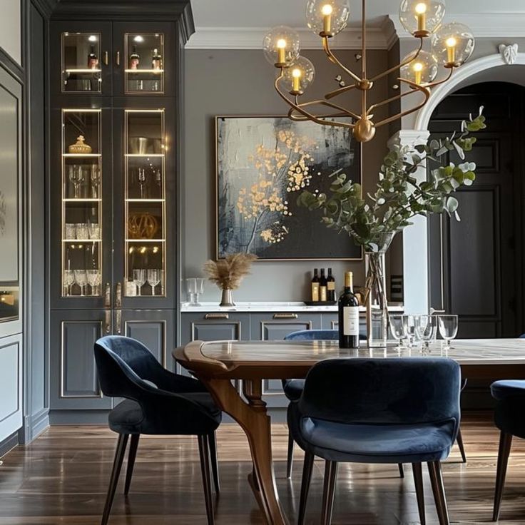 a dining room table with blue chairs and a chandelier hanging from the ceiling