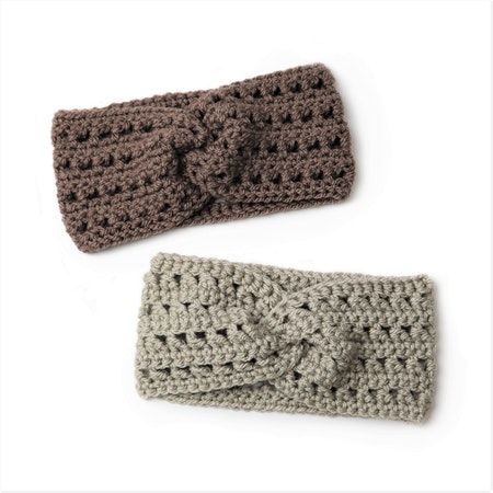 two crocheted headbands are shown on a white surface, one is brown and the other is gray