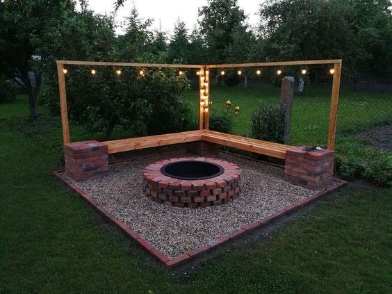 an outdoor fire pit with lights around it