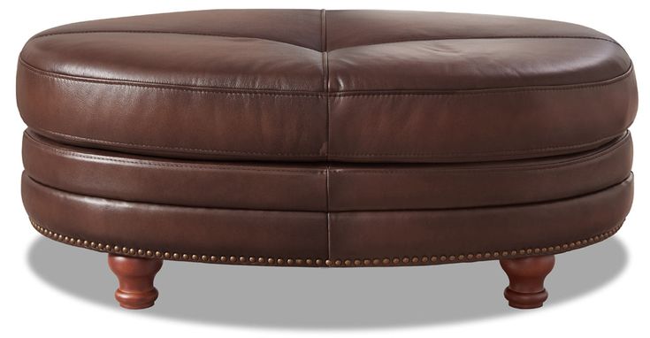 a brown leather ottoman sitting on top of a wooden table