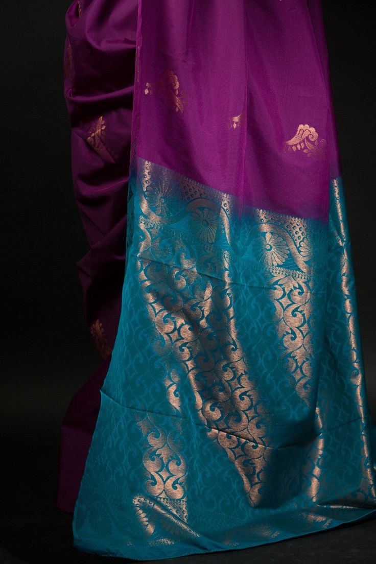 Get ready to turn heads with this stunning silk saree! The beautiful purple and azure blue color combination of this Silk saree will make a strong statement no matter where you go. Intricate gold embroidery work along the pallu adds a bit of traditional flair that makes this saree perfect for special occasions. Whether you're attending a wedding or hitting up an office party, this classic yet eye-catching look is sure to make your mark on any setting. Plus, you'll stay comfortable since the lush fabric of silk wraps around you like second skin. Make an unforgettable impression with this regal and unique ensemble! Purple Art Silk Pre-draped Saree With Self Design, Blue Chanderi Pre-draped Saree With Motifs, Bollywood Style Purple Handloom Pre-draped Saree, Traditional Purple Tissue Silk Pre-draped Saree, Blue Silk Pre-draped Saree For Traditional Ceremonies, Purple Katan Silk Pre-draped Saree With Zari Work, Purple Paithani Silk Pre-draped Saree For Wedding, Purple Pre-draped Saree With Cutdana For Traditional Ceremonies, Purple Katan Silk Pre-draped Saree With Cutdana