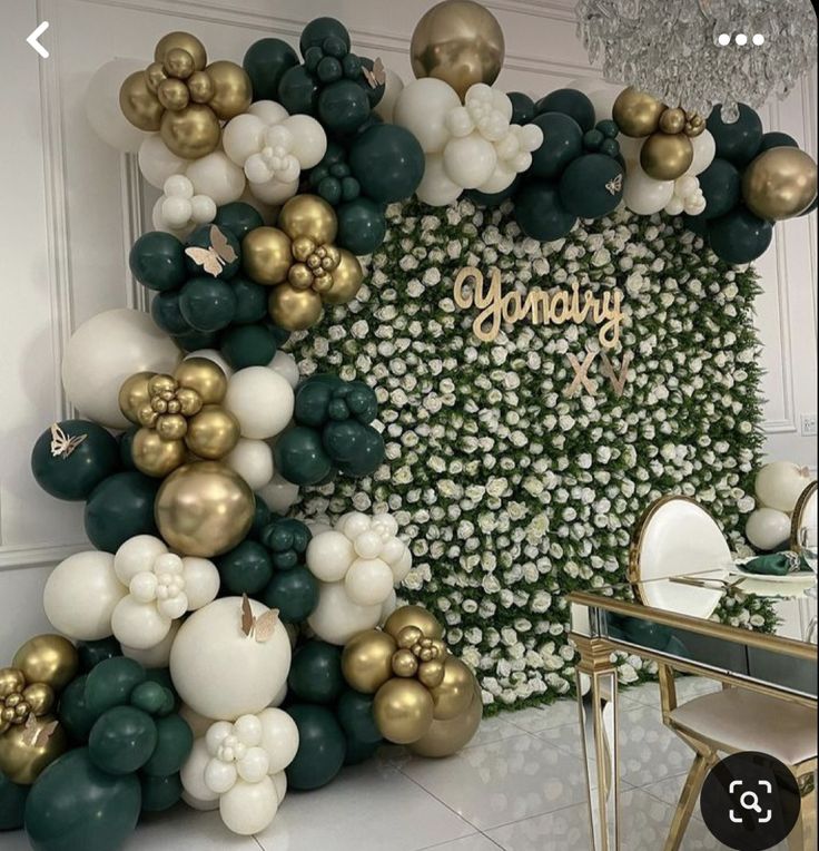 a room with balloons and greenery on the wall