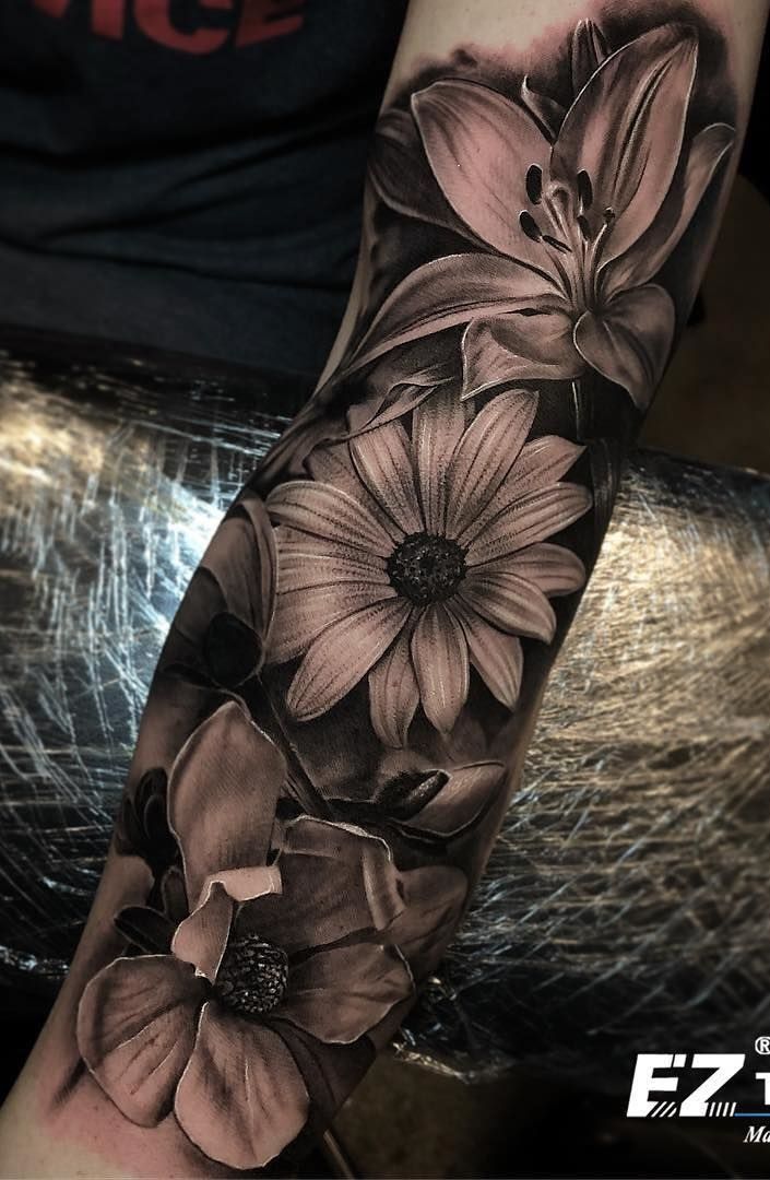 a black and white flower tattoo on the arm