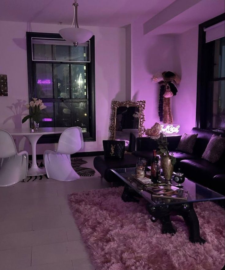 a living room filled with furniture and pink lighting