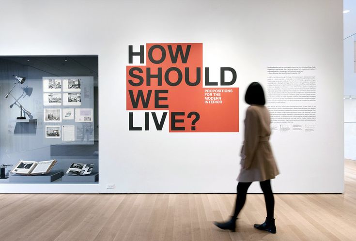 a woman is walking in front of an exhibit