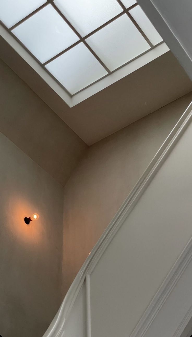 an open door leading to a bathroom with skylights on the ceiling and below it is a light fixture