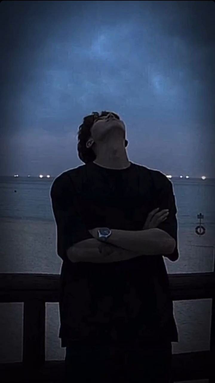 a man is looking up at the sky with his arms crossed in front of him