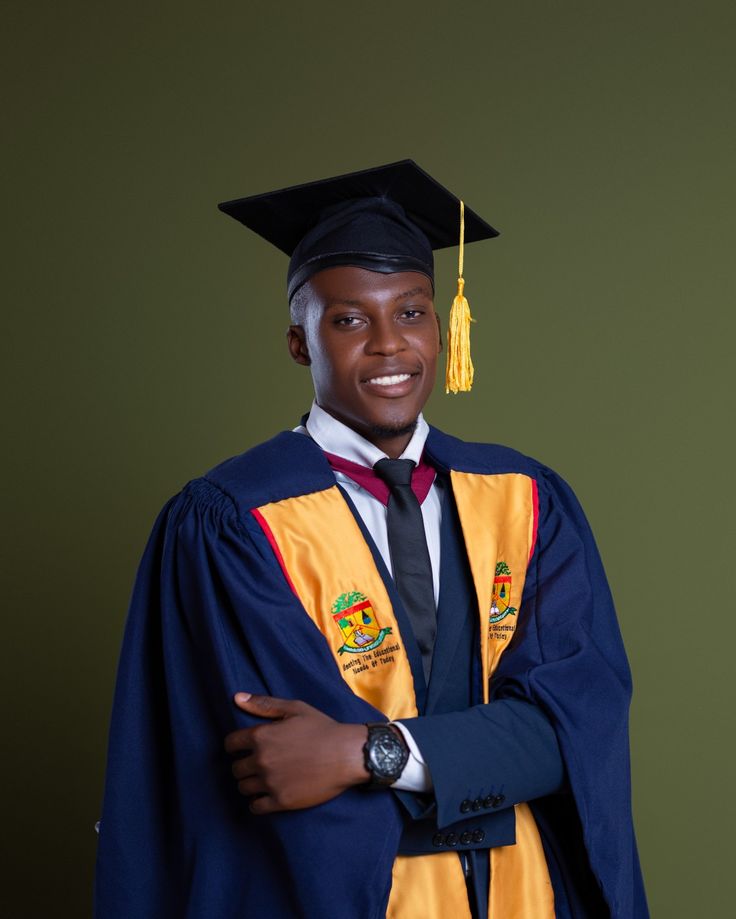 a man wearing a graduation cap and gown with his arms crossed in front of him