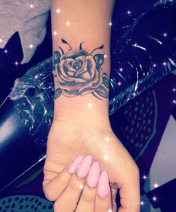 a woman's hand with a rose tattoo on it