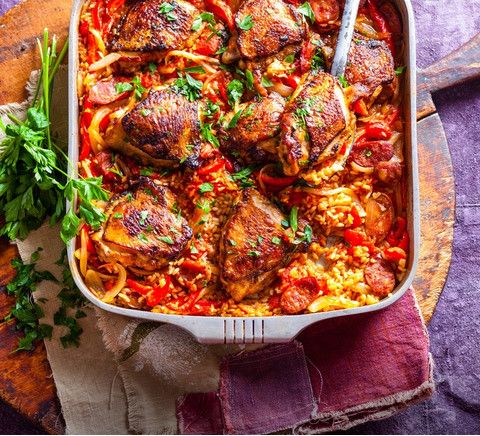 a casserole dish with meat, rice and parsley garnished with parsley