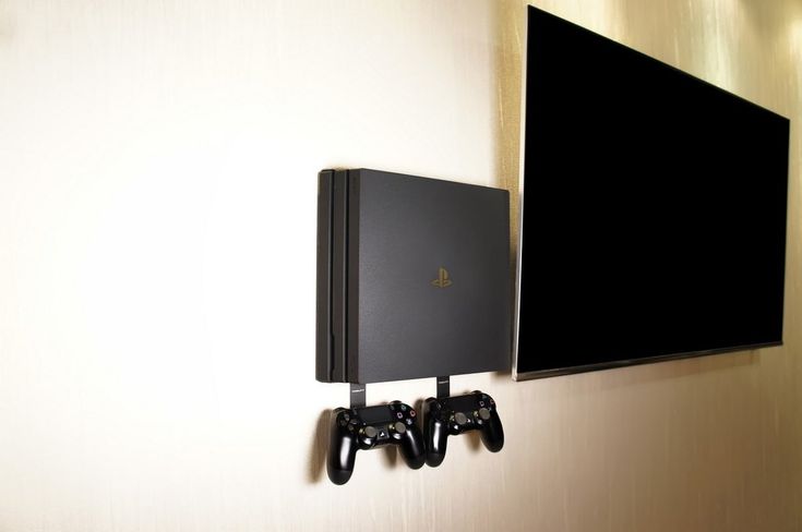 two video game controllers hanging on the wall next to a large black screen mounted above it