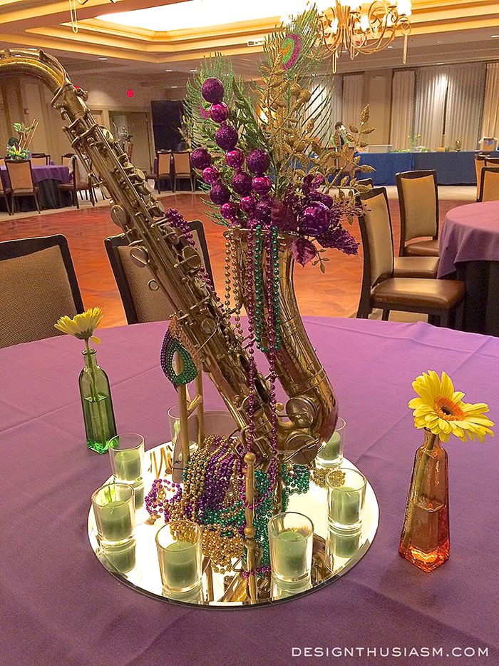 a vase filled with flowers sitting on top of a table next to a saxophone instrument