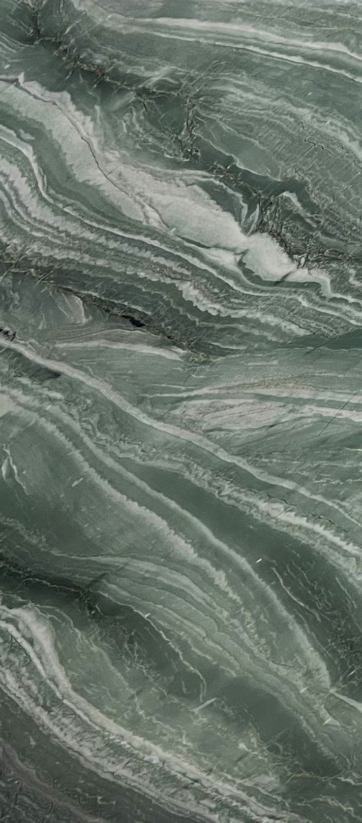 the water is green and gray with white swirls on it's surface, as seen from above