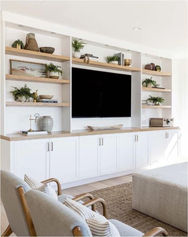 a living room filled with furniture and a flat screen tv mounted on a wall above it