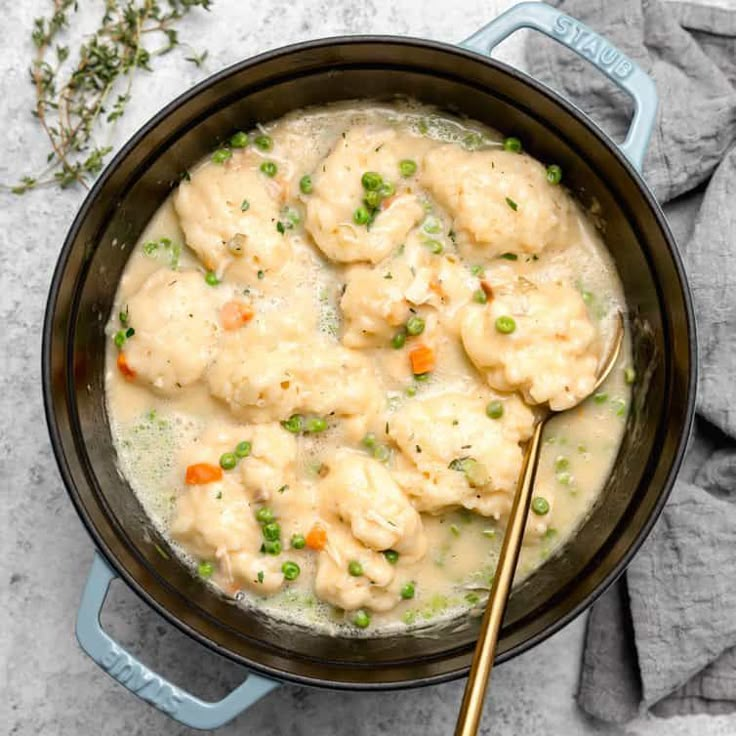 a pot filled with chicken and dumplings on top of a table