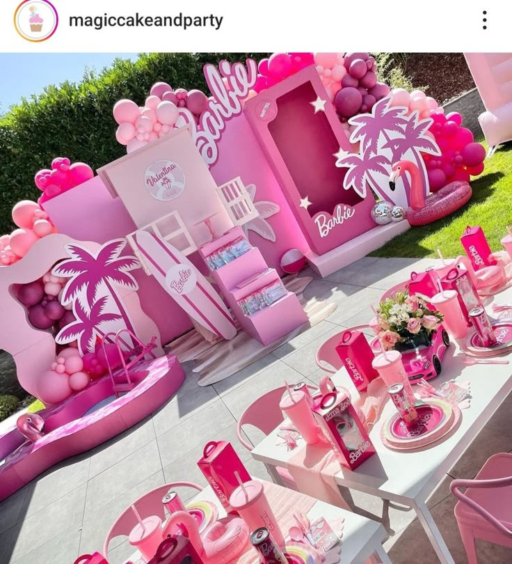 a table set up with pink decorations and balloons