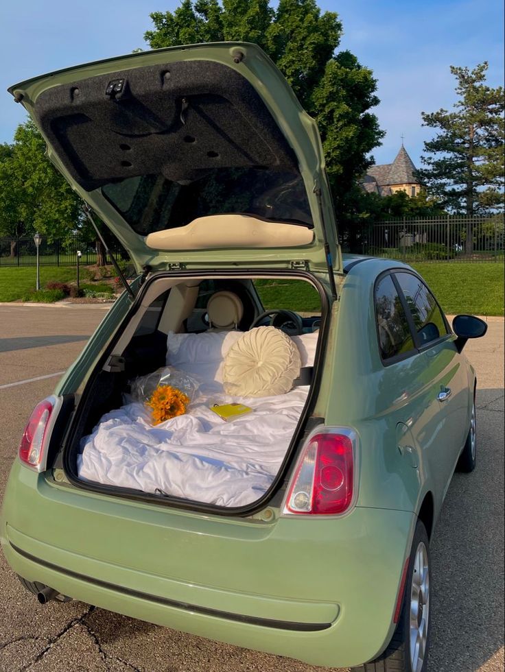 a small car with its trunk open on the street