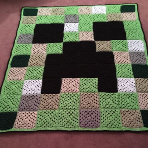 a blanket made to look like an old minecraft creeper with black and white squares on it