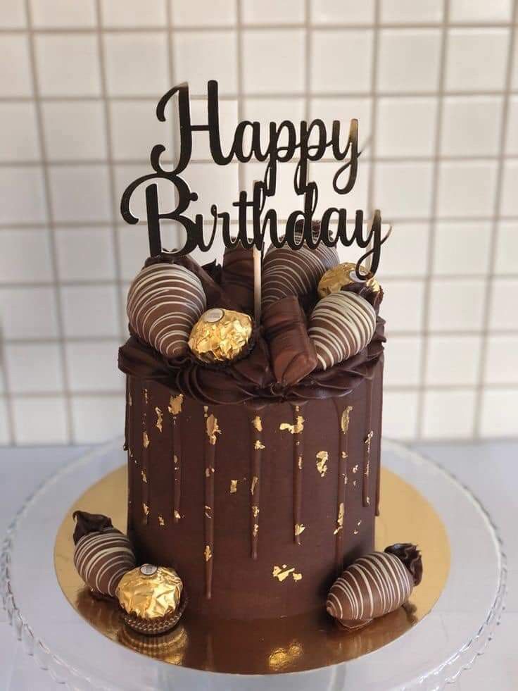 a birthday cake with chocolate and gold decorations