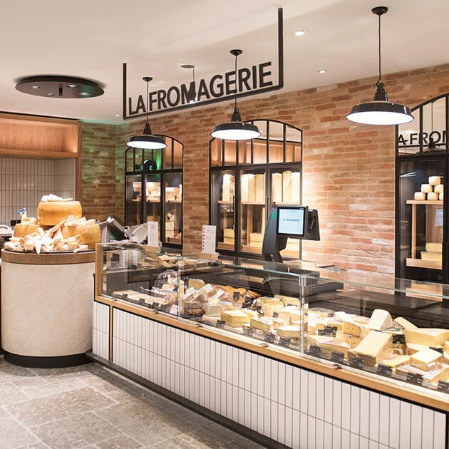 the inside of a deli with lots of cheese on display