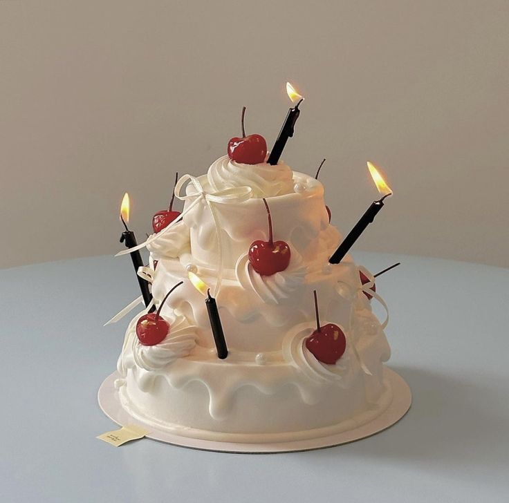 a white cake with cherries and candles on it