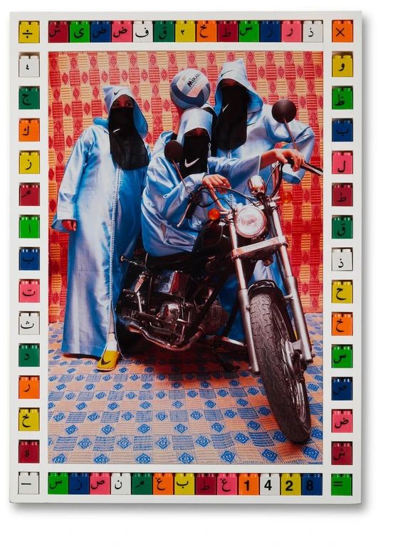 three people dressed in blue sitting on a motorbike with their heads covered by coverings