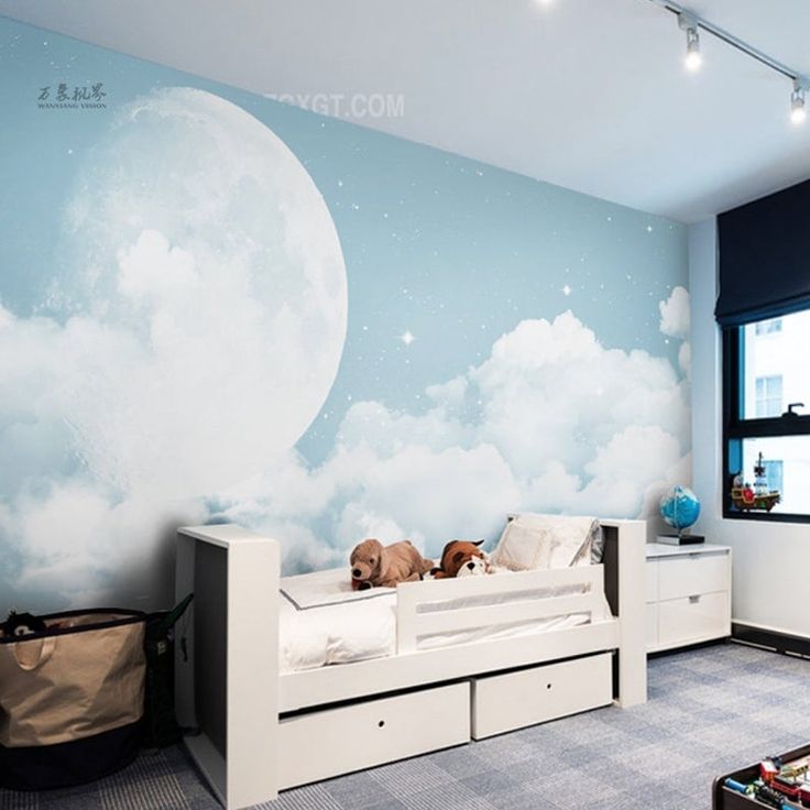 there is a dog that is laying on the bed in this room with clouds painted on the wall