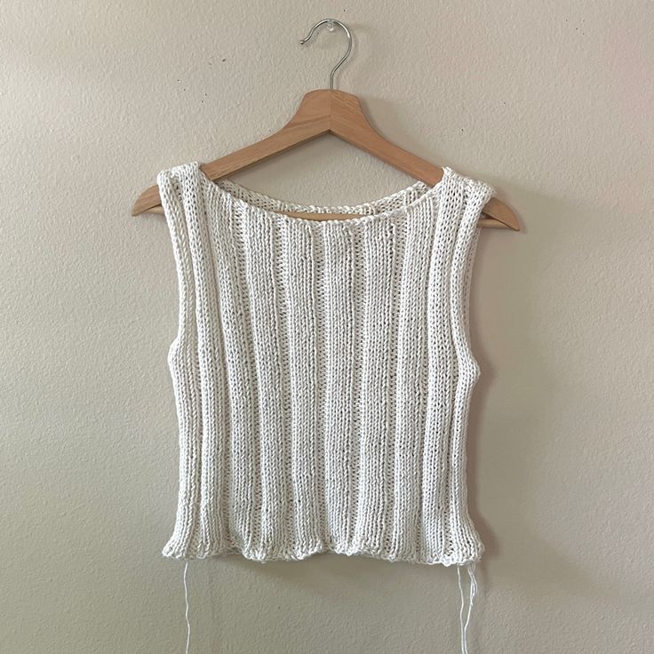 a white top hanging on a wooden hanger