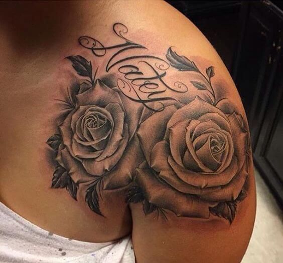 a woman's stomach with two roses and the word love tattooed on her side