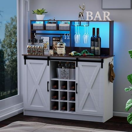 a bar with several bottles and glasses on the counter next to a potted plant