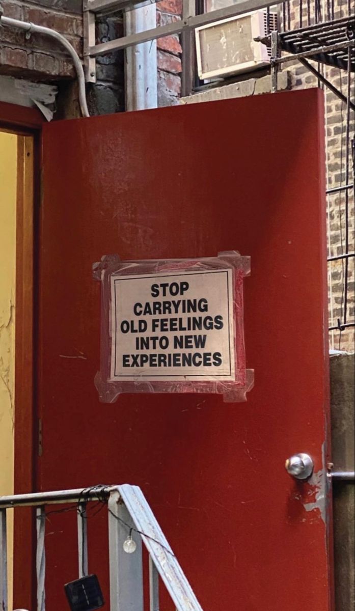 a sign on the side of a red door that says stop caffeiling old feelings into new experiences