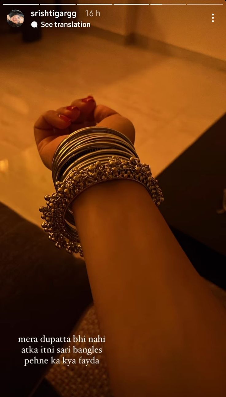 a woman's arm with bracelets and rings on it