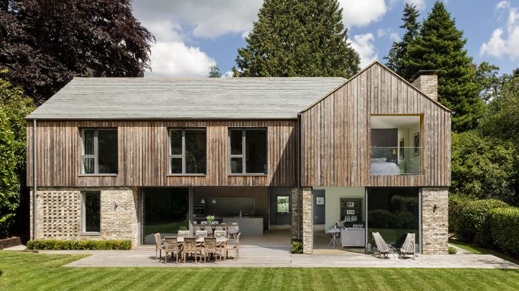 a large wooden house sitting on top of a lush green field