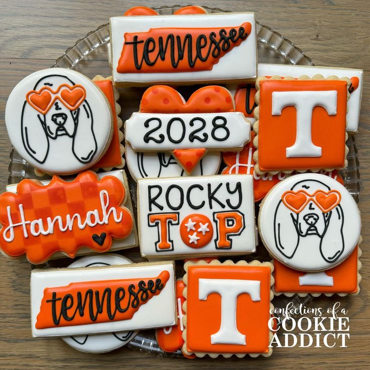 decorated cookies are arranged in the shape of letters and numbers on a platter with orange icing