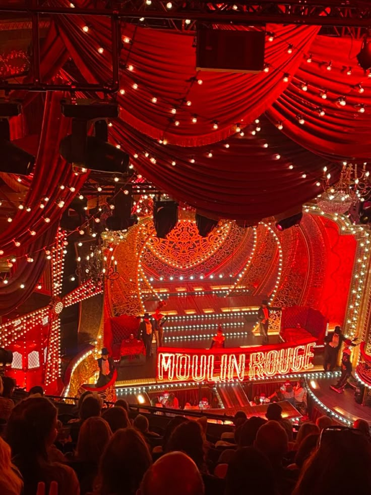 the stage is lit up with red lights and drapes on it's sides