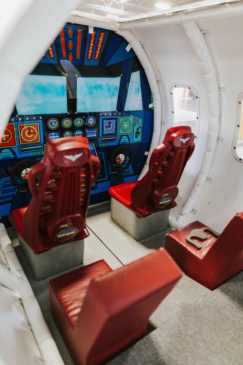 the inside of a space station with red seats