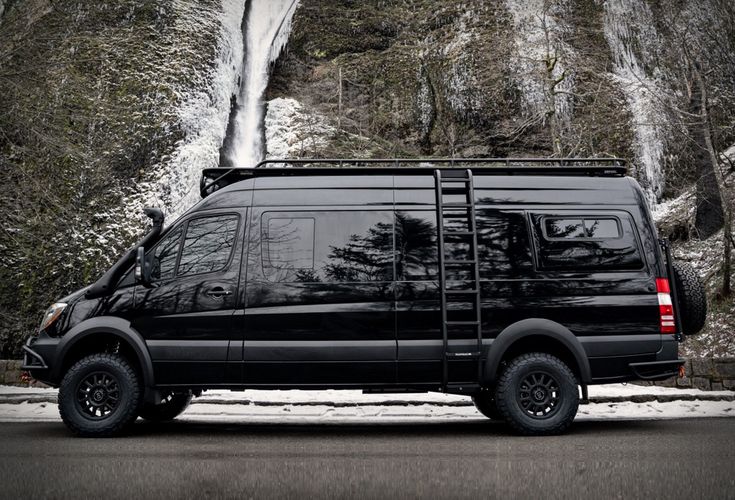 a black van parked in front of a waterfall