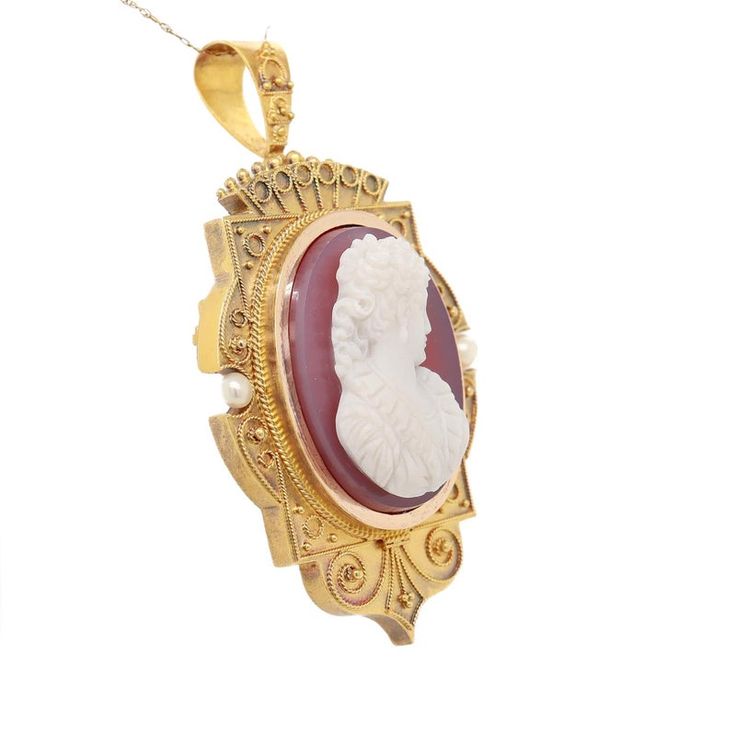 A fine antique Victorian convertible brooch / pendant for a necklace.  In 14k gold.  Comprising a cameo brooch with a oval reserve for a photo to the reverse and a tapered bail.   Centered on a pink and white carved agate or hard stone cameo of a beautiful young woman with flowing curly hair, earrings, and a ruffled dress.   The sides are set with small, round pearls and there is applied twisted rope and granulated decoration throughout.  Simply a wonderful piece of Victorian jewelry!  (Chain fo Victorian Oval Jewelry For Opera, Heirloom Style Formal Necklace With Brooch, Heirloom Cameo Pendant Jewelry, Antique Cameo Oval Cabochon Jewelry, Formal Cameo Pendant Brooch, Antique Formal Necklace With Brooch, Antique Formal Necklaces With Brooch, Antique Oval Necklace With Brooch, Antique Necklace With Brooch For Formal Occasions