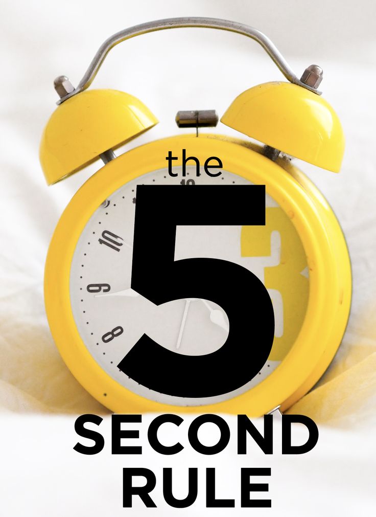 a yellow alarm clock sitting on top of a white sheet with the number five in front of it