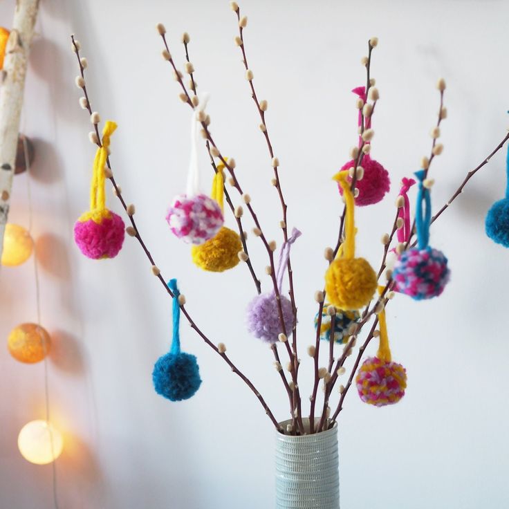 a vase filled with colorful pom - poms on top of a table