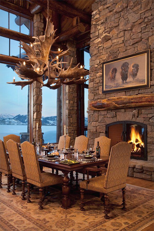 the dining room table is set with place settings for eight people and has an antler head hanging over it