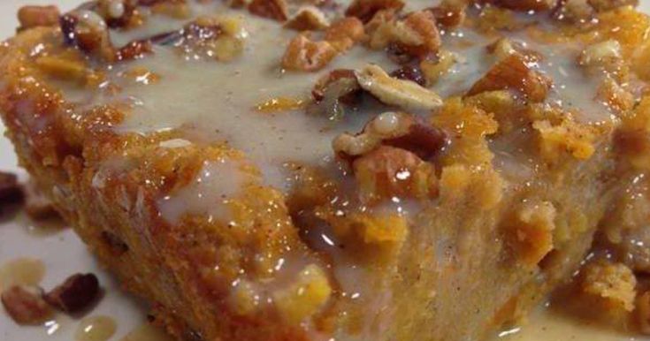 a close up of a piece of cake on a plate with icing and nuts